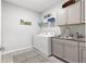 Well-organized laundry room with gray cabinets, modern washer and dryer set, and neutral decor at 7641 Sw 63Rd Lane Road, Ocala, FL 34474