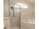 Bright bathroom showcasing a glass shower and a tiled tub with tile surround and natural light at 8170 Sw 56Th Avenue Rd, Ocala, FL 34476
