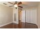 Bedroom features hardwood floors, a ceiling fan, closet, and neutral colored walls at 8170 Sw 56Th Avenue Rd, Ocala, FL 34476