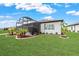 A view of the spacious backyard, featuring a large screened lanai, and lush green lawn at 8606 Sw 61St Loop, Ocala, FL 34481