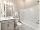 Bright bathroom with a gray vanity, modern fixtures, and a white tiled shower-tub combo at 8606 Sw 61St Loop, Ocala, FL 34481