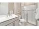 Well-lit bathroom featuring a glass shower, gray vanity, and modern fixtures at 8606 Sw 61St Loop, Ocala, FL 34481