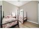 Charming bedroom with two twin beds featuring coastal-themed decor and hardwood floors at 8606 Sw 61St Loop, Ocala, FL 34481