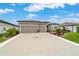 A beautifully landscaped home featuring a three-car garage and decorative driveway at 8606 Sw 61St Loop, Ocala, FL 34481