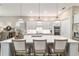 Open kitchen with quartz countertop island and seating, stainless appliances, and white cabinetry at 8606 Sw 61St Loop, Ocala, FL 34481