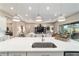 Kitchen island features bar seating, stainless steel sink, and views into the living and outdoor spaces at 8606 Sw 61St Loop, Ocala, FL 34481