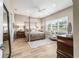 Serene main bedroom featuring a four-poster bed, wood floors, and bright windows at 8606 Sw 61St Loop, Ocala, FL 34481