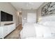 Comfortable main bedroom with a large bed, white bedding, and light hardwood flooring at 8606 Sw 61St Loop, Ocala, FL 34481