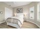Bright main bedroom with white molding, a white bedframe, and light hardwood flooring at 8606 Sw 61St Loop, Ocala, FL 34481