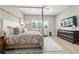A large window fills this main bedroom with natural light, with a king bed and neutral color palette at 8606 Sw 61St Loop, Ocala, FL 34481