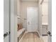 Well-organized mudroom featuring a storage bench, coat hooks, and durable flooring leading to a laundry room at 8606 Sw 61St Loop, Ocala, FL 34481