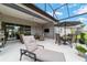 Relaxing screened-in patio with outdoor furniture and an extended view of the backyard and landscape at 8606 Sw 61St Loop, Ocala, FL 34481