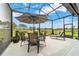 Covered outdoor patio with dining set, lounge chairs, and views of a meticulously maintained lawn at 8606 Sw 61St Loop, Ocala, FL 34481