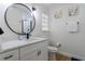 Clean bathroom with sleek vanity, modern fixtures, round mirror, and neutral color scheme at 8622 Baylor Cir, Orlando, FL 32817