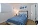 Cozy bedroom featuring light-colored wood floor, a bedside lamp, and blue accents at 8622 Baylor Cir, Orlando, FL 32817