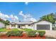 Charming single-story home with white siding, shutters, manicured lawn, and brick driveway at 8622 Baylor Cir, Orlando, FL 32817