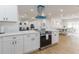 Modern kitchen featuring stainless steel appliances, white cabinetry, and a stylish range hood at 8622 Baylor Cir, Orlando, FL 32817