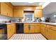 Kitchen with light wood cabinets, black appliances, and tile flooring at 8784 Sw 93Rd Ln # A, Ocala, FL 34481