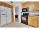 Kitchen featuring oak cabinets, black appliances, and tiled flooring at 8784 Sw 93Rd Ln # A, Ocala, FL 34481