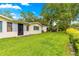 Well-maintained backyard with lush green grass and a charming exterior with a black door at 8874 Sw 95Th St # E, Ocala, FL 34481