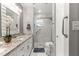 Modern bathroom featuring double vanity with granite countertop and a tiled walk-in shower with glass doors at 8874 Sw 95Th St # E, Ocala, FL 34481