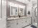 Bathroom features a double vanity with decorative lights and a tiled walk-in shower with glass door at 8874 Sw 95Th St # E, Ocala, FL 34481