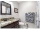 Well-lit bathroom with a granite countertop and a decorative framed mirror above the sink at 8874 Sw 95Th St # E, Ocala, FL 34481
