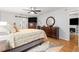Bedroom showcases wood flooring, ceiling fan, and a doorway to a living area with fireplace at 8874 Sw 95Th St # E, Ocala, FL 34481