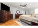 Spacious bedroom features ceiling fan, wood floor, and large dresser with mounted television at 8874 Sw 95Th St # E, Ocala, FL 34481
