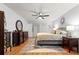 Bright bedroom features a ceiling fan, wood floors, walk-in closet, and dresser with round mirror at 8874 Sw 95Th St # E, Ocala, FL 34481