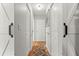 Bright hallway features a wooden floor, white walls, and multiple entry ways, with two barn doors at 8874 Sw 95Th St # E, Ocala, FL 34481