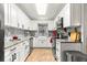 Updated kitchen features white cabinets, stainless steel appliances, granite countertops and a farmhouse sink at 8874 Sw 95Th St # E, Ocala, FL 34481