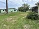 View of a grassy backyard with a partial fence and a neighboring house in a suburban setting at 8901 Sw 103Rd Ln, Ocala, FL 34481