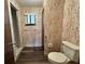A bathroom featuring patterned wallpaper, a shower, commode and window for natural light at 8901 Sw 103Rd Ln, Ocala, FL 34481