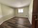 Bedroom features neutral walls, wood-look vinyl floors, and natural light from the window at 8901 Sw 103Rd Ln, Ocala, FL 34481