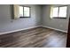 A spacious bedroom with gray walls and brown wood-look vinyl floors under natural light from two windows at 8901 Sw 103Rd Ln, Ocala, FL 34481