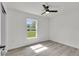 Bright bedroom with laminate flooring, a ceiling fan, and a large window with a view of the outdoors at 904 Nw 67Th St, Ocala, FL 34474