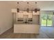 Open kitchen with an island, granite countertops, pendant lighting, and access to the backyard at 904 Nw 67Th St, Ocala, FL 34474