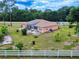 Backyard shot with white fencing, showcasing a home with solar panels and an open, green space at 9325 Sw 125Th Court Rd, Dunnellon, FL 34432