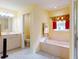 Bathroom showcasing a tub, shower, vanity, and window with elegant curtains at 9325 Sw 125Th Court Rd, Dunnellon, FL 34432