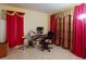 Bright bedroom featuring red curtains, a desk area, and a comfortable workspace at 9325 Sw 125Th Court Rd, Dunnellon, FL 34432