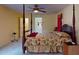 Stately primary bedroom featuring 4-poster bed, ceiling fan, and access to the ensuite bathroom at 9325 Sw 125Th Court Rd, Dunnellon, FL 34432