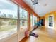 Bright sunroom featuring large windows, wood floors, and natural light offering backyard views at 9325 Sw 125Th Court Rd, Dunnellon, FL 34432