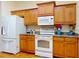 Well-equipped kitchen with white appliances, wooden cabinets, and granite countertops at 9325 Sw 125Th Court Rd, Dunnellon, FL 34432