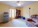 Bright living room with a ceiling fan, a comfortable chair, a bookcase, and a window with curtains at 9325 Sw 125Th Court Rd, Dunnellon, FL 34432
