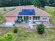 Aerial view of a single-story home featuring solar panels, a patio, and a well-maintained lawn at 9325 Sw 125Th Court Rd, Dunnellon, FL 34432