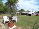 Large grassy backyard has a fire pit and is backed by the home and a neighboring lot at 9430 Sw 102Nd Pl, Ocala, FL 34481