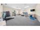 Spacious carpeted exercise room with windows and a variety of fitness equipment including treadmill and free weights at 9430 Sw 102Nd Pl, Ocala, FL 34481