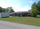 Single-story home with a well-maintained lawn, screened porch, and extra storage shed at 9430 Sw 102Nd Pl, Ocala, FL 34481