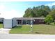 Well-maintained home with a screened-in porch and an adjacent storage shed, nestled on a green lawn at 9430 Sw 102Nd Pl, Ocala, FL 34481